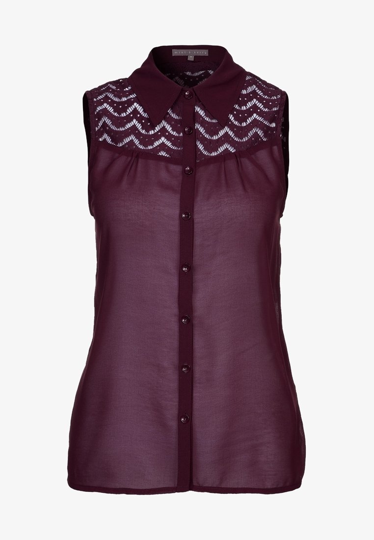 Blusa borgogna senza maniche con un pannello in pizzo testurizzato, apertura frontale con bottoni e colletto. Realizzata in un tessuto leggero e trasparente.