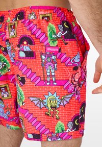 Colorful swim shorts with a vivid red brick pattern featuring animated characters, stairs, and vibrant accents. Includes a side pocket and elastic waistband.