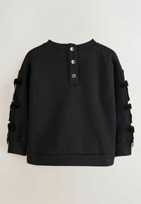 Felpa nera con scollo rotondo, tre bottoni decorativi sul retro e maniche testurizzate con dettagli in nastro.