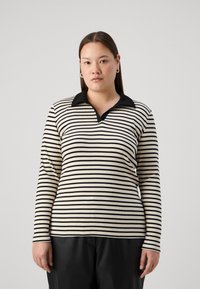 Polo de manga larga a rayas en negro y crema, con cuello negro y tejido texturizado, en una silueta ajustada.