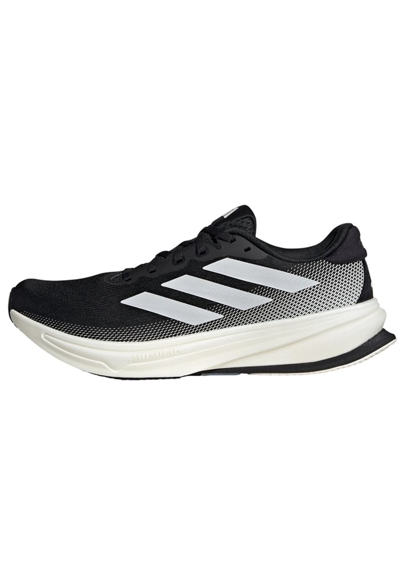 Chaussure de sport noire avec un design en maille, ornée de rayures blanches, à bout arrondi et avec une semelle texturée pour une meilleure adhérence et un soutien accru.