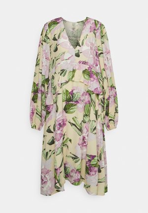 Vestido floral com decote em V, mangas bufantes longas e design em camadas. Apresenta grandes estampas de peônias cor-de-rosa sobre um fundo amarelo claro.