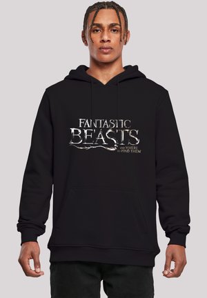 Svart hettegenser med frontlomme som har hvit tekst: "FANTASTISKE BEASTS og HVOR DU FINNER DEM." Mykt materiale, avslappet passform.