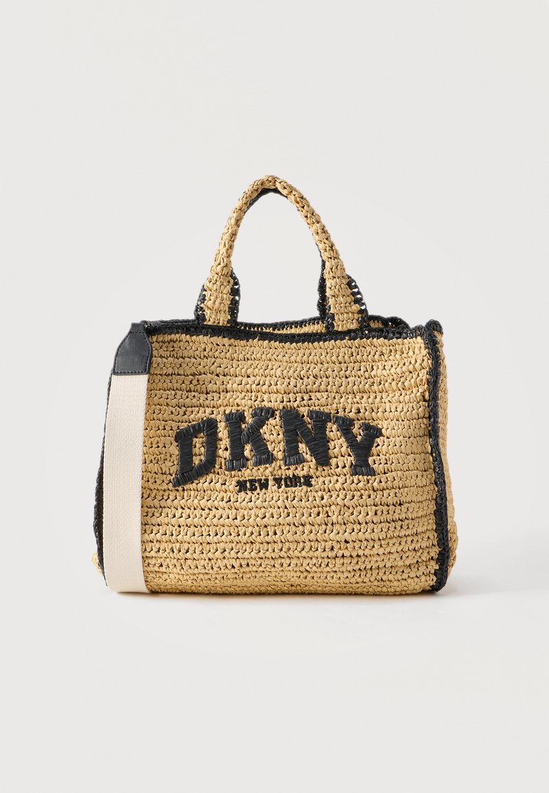 Sac fourre-tout en paille tissée avec bordure noire, poignées courtes, bandoulière beige et logo DKNY New York en noir audacieux sur le devant.