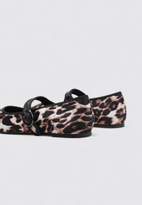 Flache Schuhe mit einem Schwarz-Braun-Leopardenmuster, ausgestattet mit einem runden Schnallenriemen und aus weichem Stoffmaterial. Geeignet für legere Anlässe.