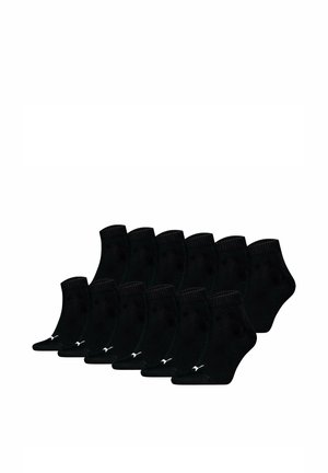 Douze paires de chaussettes noires basses disposées en deux rangées, chacune avec un petit logo blanc Puma près des orteils.