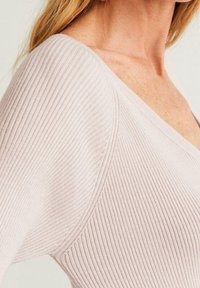 Helles rosa, geripptes Sweatshirt mit V-Ausschnitt und strukturiertem Stoff. Die Nahaufnahme zeigt die taillierte Form des Sweatshirts und die Nahtdetails.