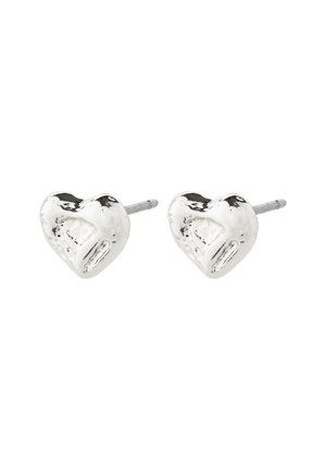 Paire de boucles d'oreilles clous argentées brillantes en forme de cœur avec des surfaces légèrement irrégulières et texturées et des tiges droites.