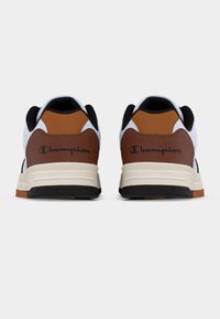 Λευκά και καφέ αθλητικά παπούτσια με μαύρες λεπτομέρειες, με υφασμένη καφέ φτέρνα και λογότυπο της μάρκας. Λαστιχένια σόλα με ραμμένο σχέδιο.