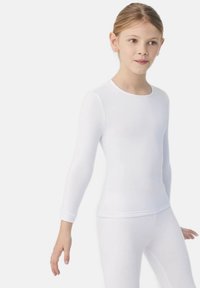 Camiseta blanca de manga larga hecha de una tela suave y elástica, con un escote redondo y un diseño ajustado, combinada con leggings blancos a juego.