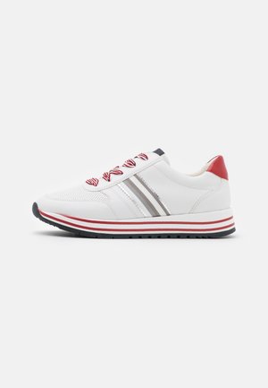Hvid sneaker med røde accenter, røde og hvide stribede snørebånd, grå striber på siden og en sort skridsikker sål vist fra siden.