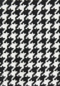 Motivo pied de poule in bianco e nero con tessitura strutturata, caratterizzato da forme a zigzag nette su uno sfondo contrastante.