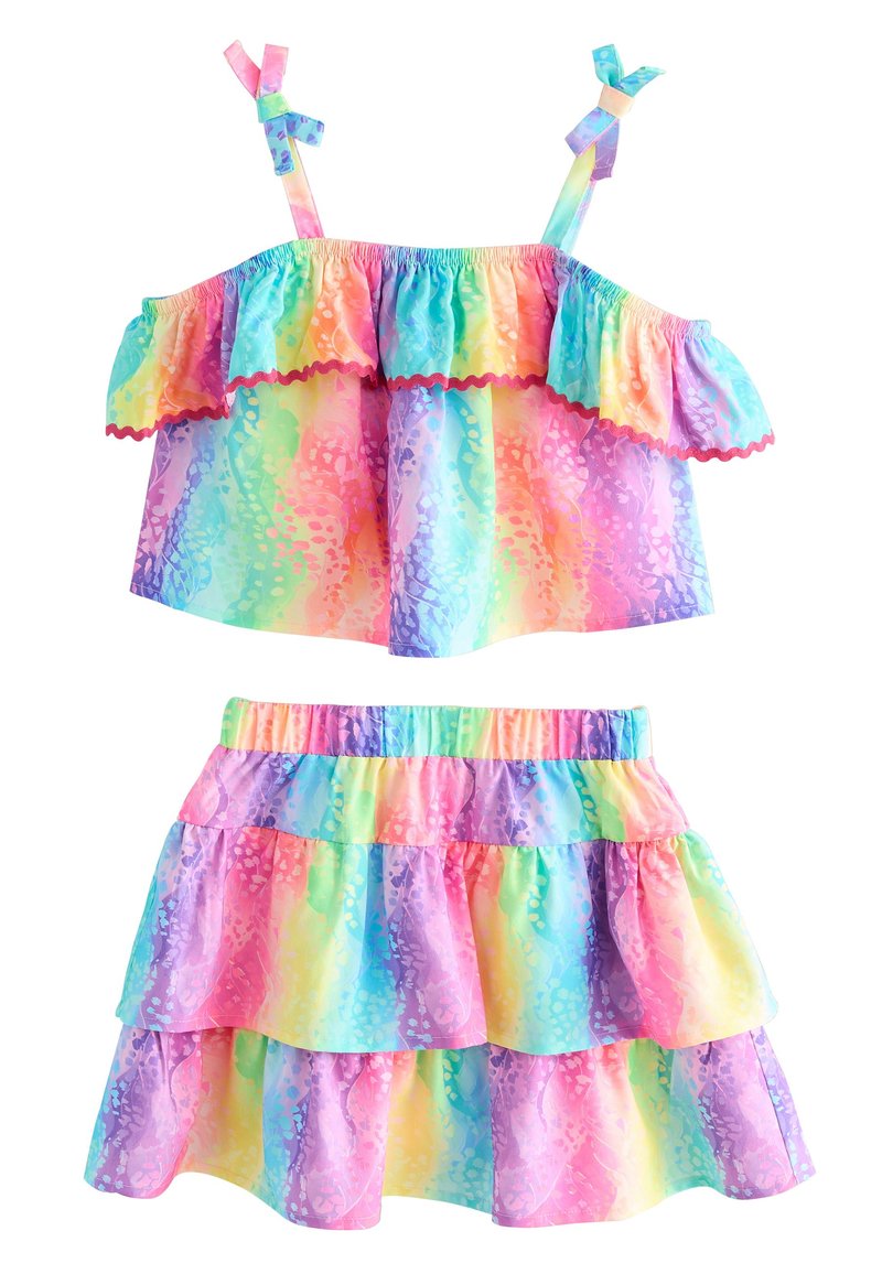 Tvådelad outfit med en flervarvad crop top med volanger och en lager-på-lager kjol, båda i pastellfärger med tie-dye-mönster och elastisk midja.