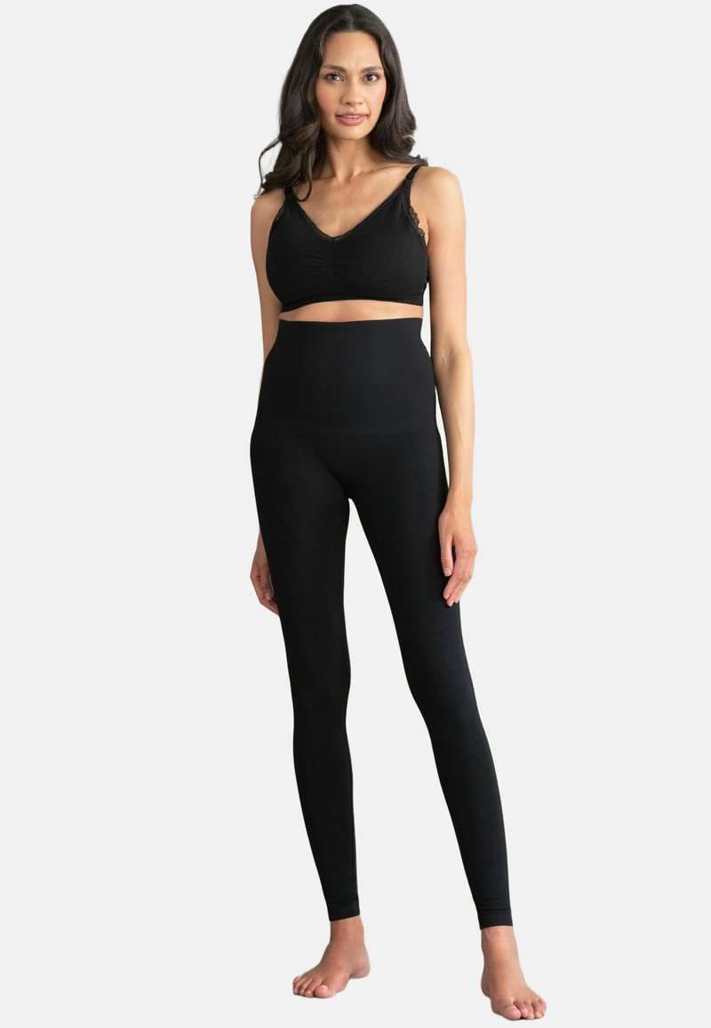 Sujetador deportivo negro con ribete de encaje y leggings negros de cintura alta, ambos hechos de un material liso y elástico, presentados en una modelo.