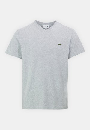 Szary T-shirt w serek wykonany z miękkiego materiału. Posiada krótkie rękawy i małe zielone logo Lacoste na lewej piersi. Prosty design.