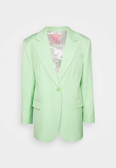 Blazer vert clair en tissu texturé. Présente un col cranté, une fermeture à un bouton et deux poches avant. Doublure en satin.