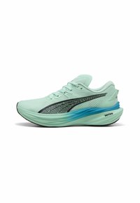 Hellgrüner Laufschuh mit Netz-Obermaterial, schwarzem Streifen und blauen Akzenten an der Sohle. Verfügt über Schnürsenkel und eine gepolsterte Mittelsohle.