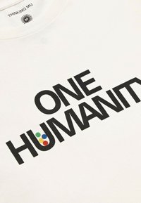 Weißes Baumwoll-Sweatshirt mit fettem schwarzen Text "EINE MENSCHHEIT". Der Buchstabe "U" enthält fünf farbige Punkte: rot, gelb, grün, blau und schwarz.