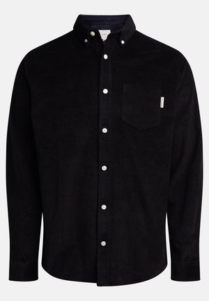 Chemise noire en velours côtelé à manches longues avec boutons blancs, col boutonné et poche poitrine côté gauche.