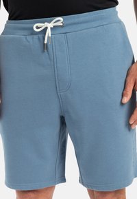 Lichtblauwe jersey shorts met een elastische tailleband, trekkoord en zijzakken; zachte textuur en gestikte details.