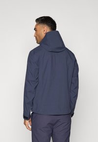 Navy waterproof jacket with a high collar and hood, featuring elastic cuffs and a smooth texture. Minimalistic design with no visible logos.