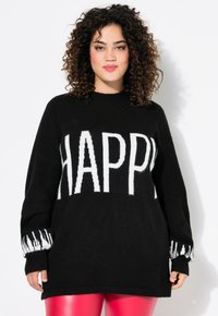 Schwarzer Pullover mit auffälligem weißen Text "HAPPY" auf der Vorderseite, langen Ärmeln mit weißen Akzenten und legerer Passform. Texturiertes Strickgewebe.