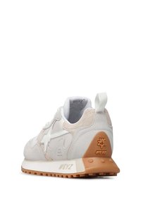 Le sneakers presentano una parte superiore in mesh bianco e suede beige, un design a stella prominente e una suola in gomma marrone testurizzata con dettagli di branding.