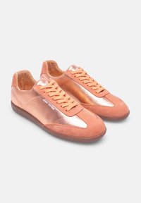 Sneakers eleganti in materiale rosa liscio, con un accento metallico lucido sul lato, suede testurizzato e lacci arancioni a contrasto.