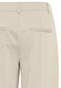 Beige trousers made of a smooth fabric, featuring back pockets with flat closures and a straight-leg design.