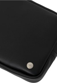 Custodia per laptop in pelle nera con texture liscia, bordi arrotondati e un pulsante logo in argento, con dettagli di cucitura sottili.