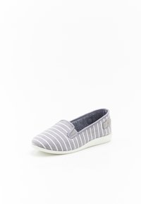Scarpa slip-on grigia con strisce orizzontali bianche, materiale in tela, punta arrotondata e suola in gomma bianca. Include accenti laterali testurizzati.