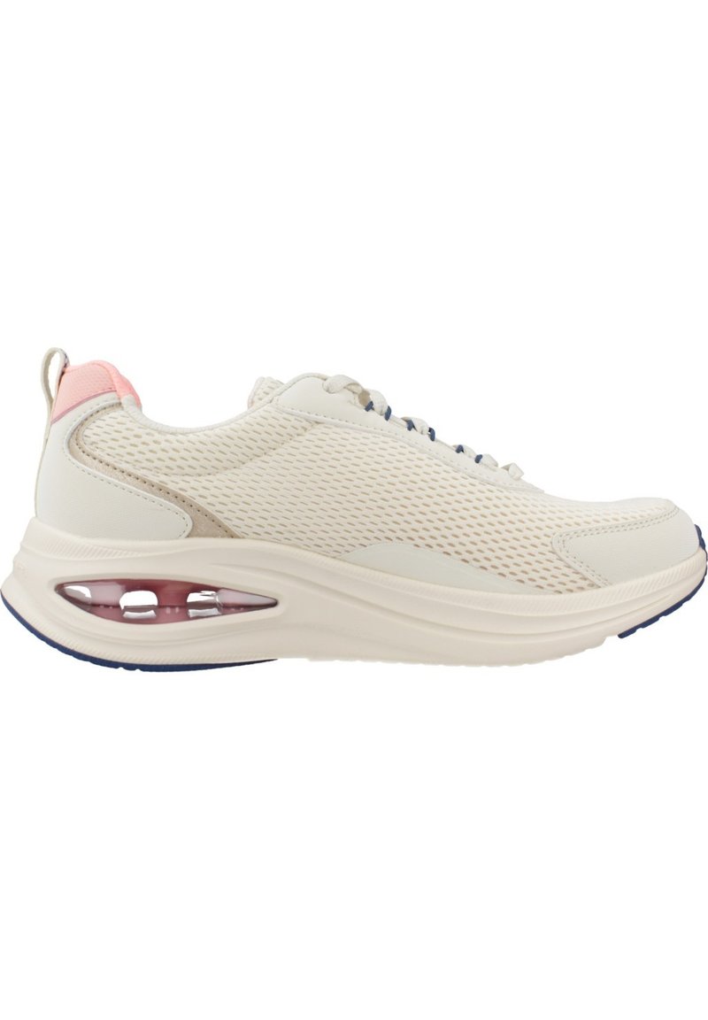 Zapatilla deportiva de malla color beige claro con lengüeta trasera rosa, cojín de aire visible en la suela y detalles en azul marino en la suela, vista lateral.