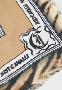 Selyem sál bézs és fekete tigriscsíkos mintával, élénk fekete kerettel, melyen a "JUSTCAVALLI" felirat található.