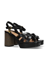 Černé kožené platformové sandály s křížovými pásky a vrstveným pruhovaným podpatkem. Obsahují texturovaný detail a malý zlatý akcent.