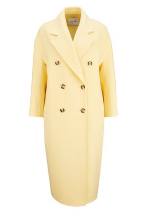 Long manteau croisé jaune pastel avec six boutons, larges revers et manches trois-quarts, présenté sur un fond blanc.