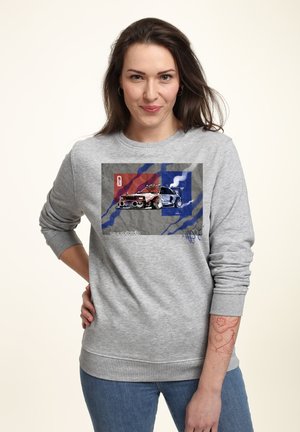 Grijze sweatshirt met een afbeelding van een rode en blauwe auto op een grijze achtergrond, met blauwe en rode kwaststreekaccenten.