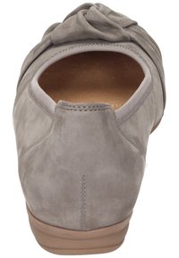 Scarpa in suede grigia con punta tondeggiante e dettaglio annodato nella parte anteriore. La suola è in gomma beige, evidenziando una tomaia morbida e strutturata.