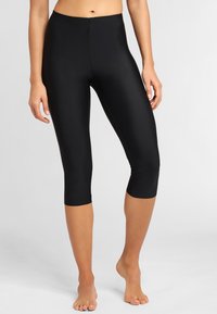 Black yoga capri leggings made from smooth, stretchy fabric with a mid-rise waistband, hitting just below the knee.