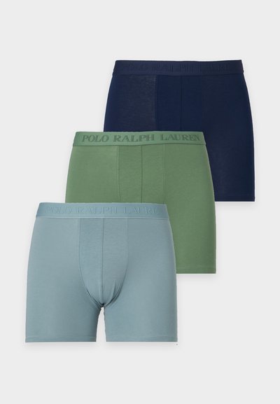 Τρία στοιβαγμένα boxer Polo Ralph Lauren σε μπλε, πράσινο και ανοιχτό μπλε με αντίστοιχες μέσες ζώνες που φέρουν ανάγλυφο το όνομα της μάρκας.