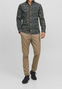 Laivastonsininen kukkakuvioinen pitkähihainen nappipaita, jossa värikkäitä kuvioita. Yhdistetty vaaleanruskeisiin housuihin ja mustiin nauhallisiin kenkiin.