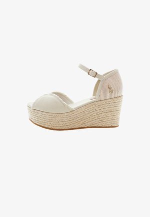 Beige canvas wedge sandals dengan midsole jute anyaman yang tekstur, tali pergelangan kaki yang dapat disesuaikan, dan desain ujung bulat.