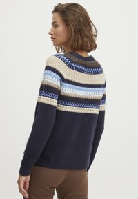Strikket sweater med navy, beige og blå striber samt geometriske mønstre. Rund halsudskæring, ribbede manchetter og tekstureret stof.