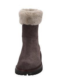 Bruine suède winterlaars met dikke zwarte rubberen zool en lichtbeige nepbont manchet dat over de bovenkant is gevouwen.