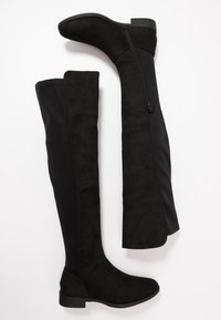 Botas negras sobre la rodilla, que presentan una combinación de ante y tejido elástico, con un tacón delgado y un detalle de cremallera lateral.
