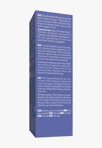 Fioletowe opakowanie na olejek do włosów o właściwościach odżywczych, z wieloma językami, teksturowanym wykończeniem oraz białym i srebrnym tekstem.