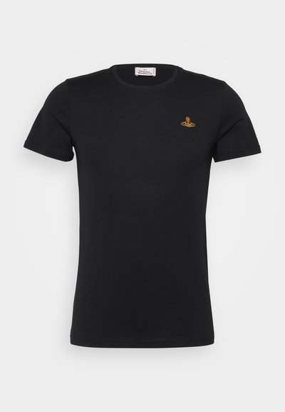 Μαύρο βαμβακερό μπλουζάκι με κοντά μανίκια, στρογγυλή λαιμόκοψη και ένα μικρό κίτρινο λογότυπο στο επάνω αριστερό στήθος. Λείος υφασμάτινος ιστός.