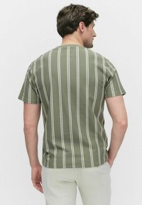 Groen gestreepte korte mouwen shirt met witte verticale lijnen. Zachte stof, ronde hals, casual pasvorm. Gekocht met lichte broek.