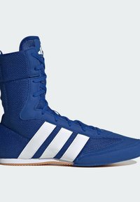 Chaussure de sport montante bleue avec une texture en mesh, trois bandes blanches sur le côté, des lacets bleus et une semelle marron clair.