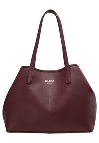 Bordeauxrode leren handtas met twee lange handvatten, een gestructureerd oppervlak en zilveren logodetails aan de voorkant. Ruimtelijk en gestructureerd ontwerp.