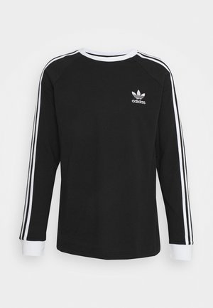 Chemise noire à manches longues avec un motif à trois bandes blanches sur les manches, un col côtelé blanc contrasté, et un petit logo adidas blanc sur la poitrine.